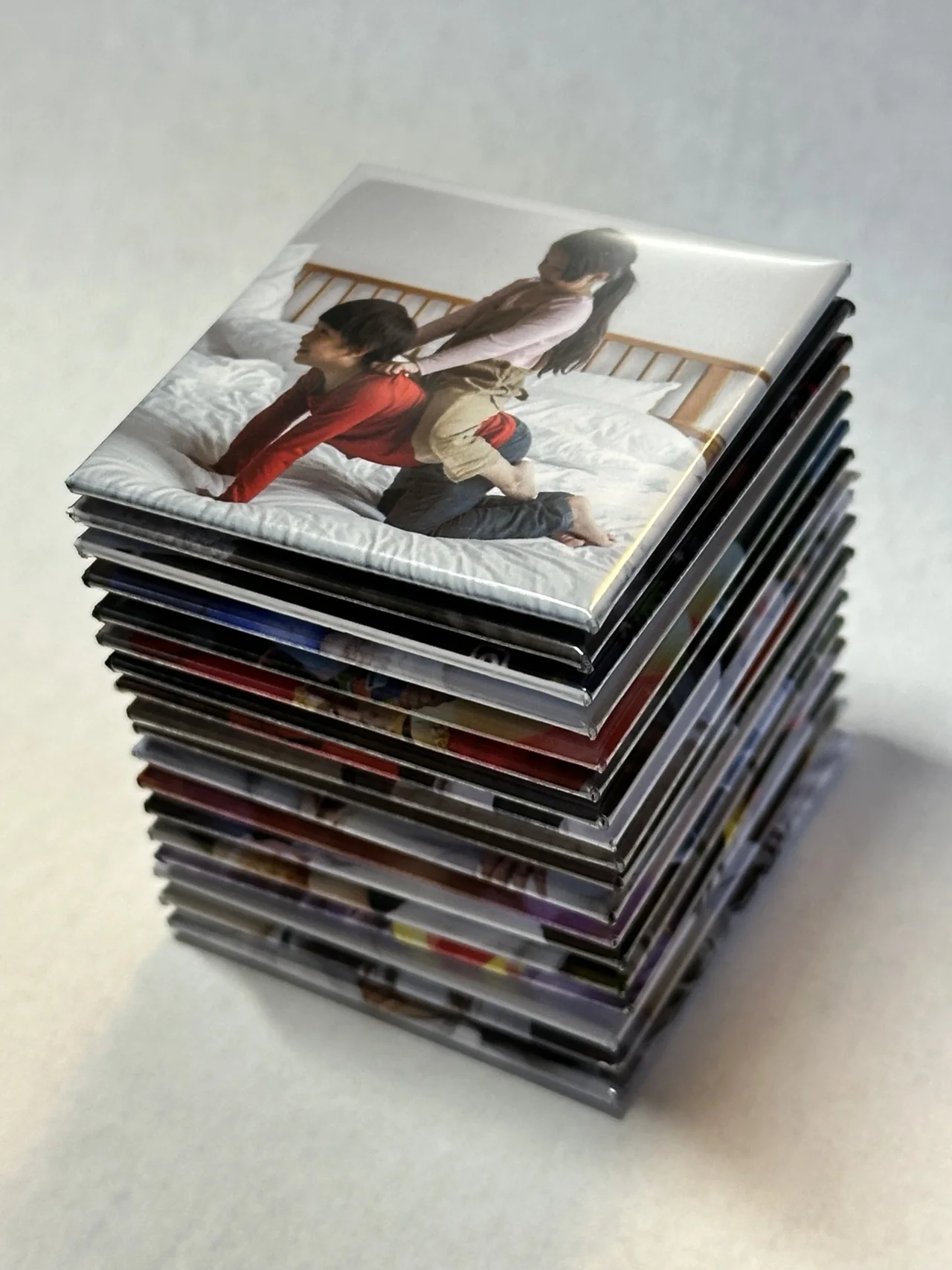 An overhead view of a stack of TAGO family photo magnets