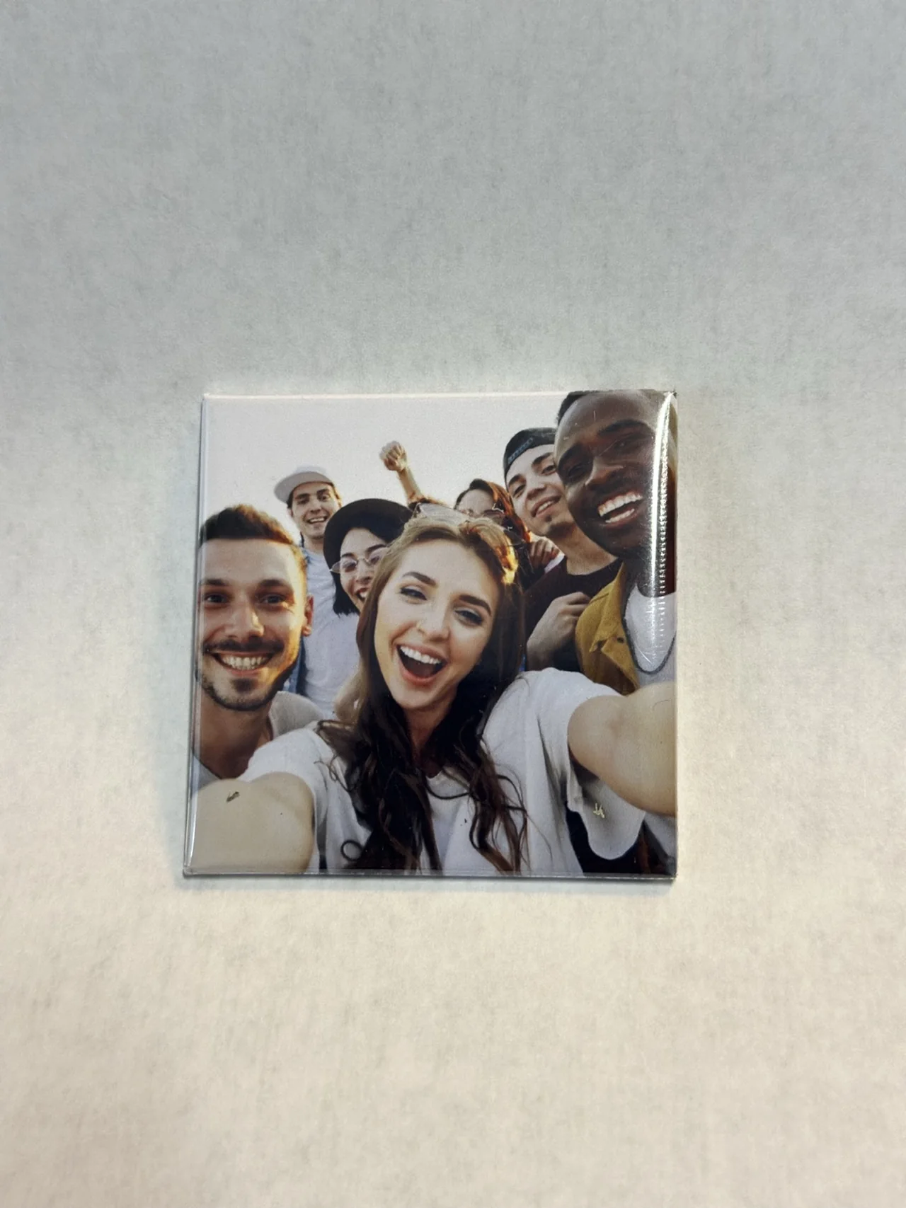 A finished TAGO magnet featuring a group of friends taking a selfie