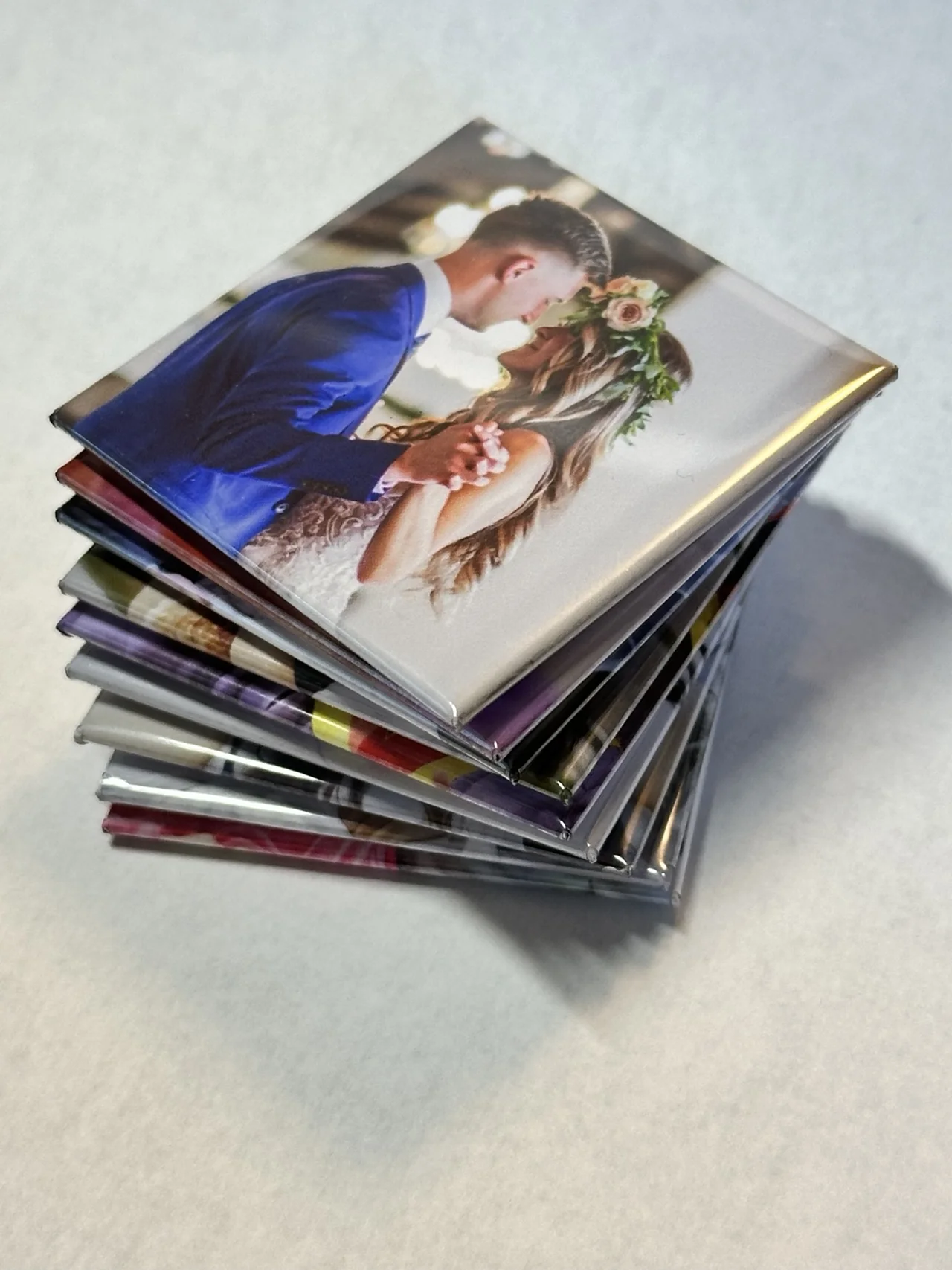A stack of finished TAGO photo magnets with a wedding photo on top