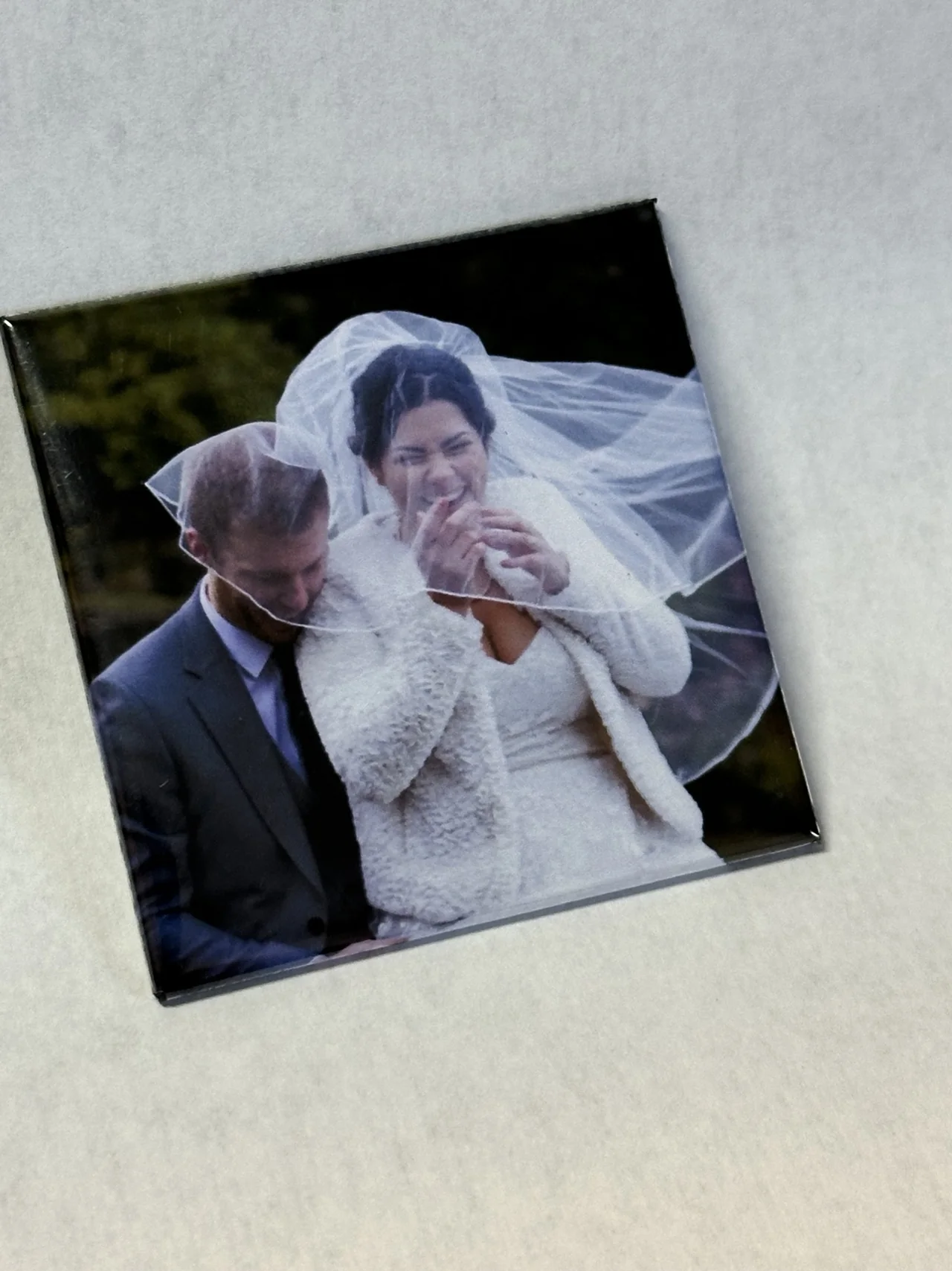 An angled close-up of a TAGO wedding photo magnet